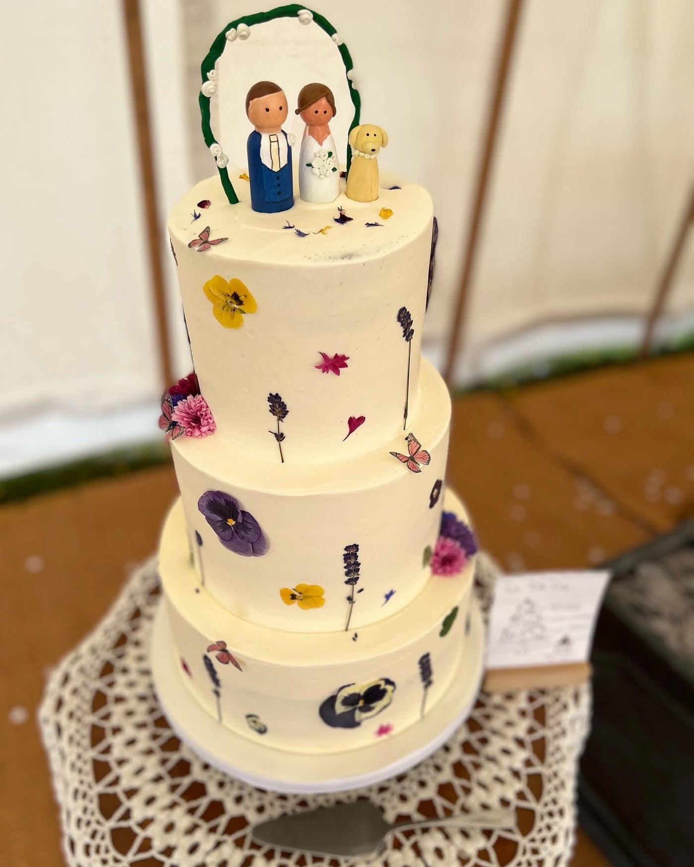 Edible flower adorned buttercream wedding cake