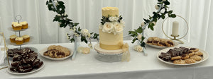 Dessert table full of stuffed cookies, brownies, cupcakes and the Wedding Cake.